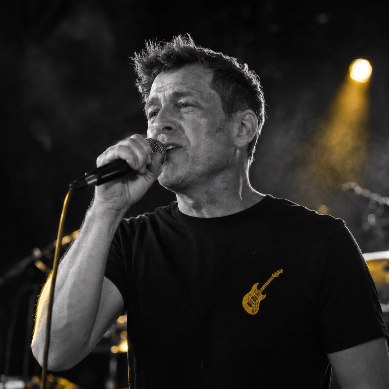 Portrait von Tim mit Mikrofon, live auf der Bühne